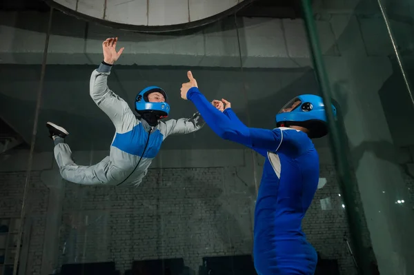 stock image A male instructor teaches a woman how to fly in a wind tunnel. Free fall simulator