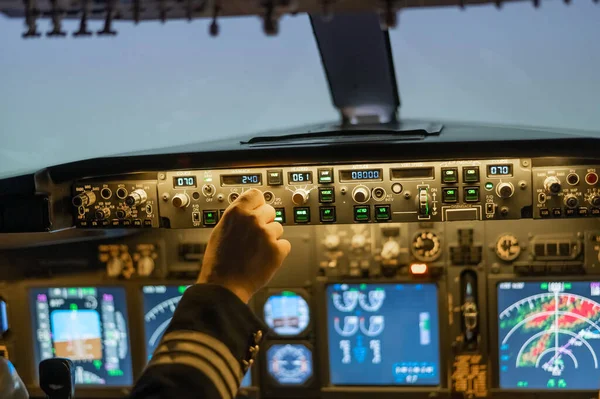 A man is studying to be a pilot in a flight simulator. Close-up of male hands on the control panel of an aircraft