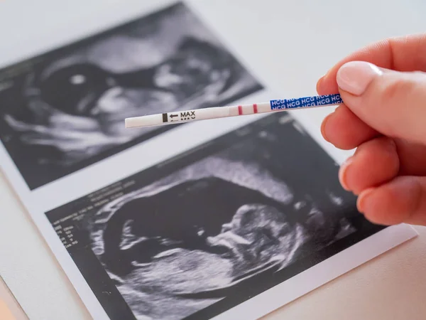 超音波で写真の背景に正の妊娠検査をしている女性 — ストック写真
