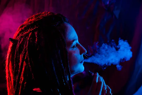 Perfil Chica Caucásica Con Rastas Fuma Vapor Luz Azul Roja —  Fotos de Stock