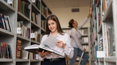 Halk kütüphanesinde iki genç kız öğrenci.