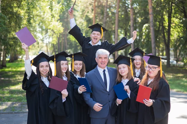 大学教授と7人の卒業生が卒業を喜ぶ — ストック写真