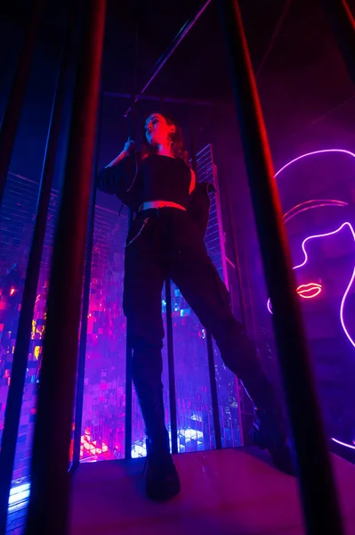 Çelik Parmaklıkların Arkasındaki Neon Stüdyodaki Beyaz Kadın — Stok fotoğraf