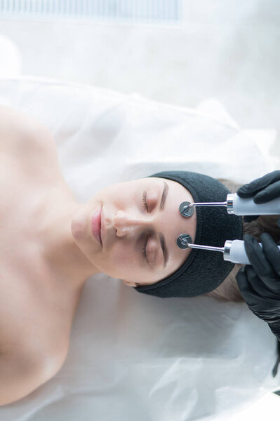 Молодая белая женщина на процедуре микротоковой терапии. Офис ботаника