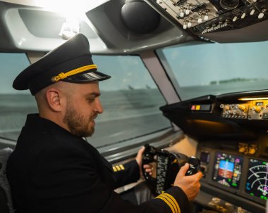 Uçuş simülatöründe otururken gülümseyen beyaz sakallı adam. Pilot kokpitte.