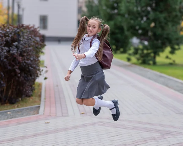 Šťastný Kavkazský Dívka Uniformě Batohem Skákání Venku Škole — Stock fotografie