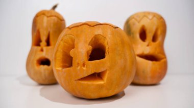 Beyaz arka planda üç tane Jack-o-Lantern. Cadılar Bayramı dekorasyonu