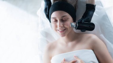 Ultrasonik temizlik prosedürü uygulayan bir kadın. Donanım kozmetolojisi