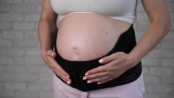 Μια Έγκυος Γυναίκα Βάζει Έναν Μαύρο Επίδεσμο Καλλιεργημένη Κοιλιά — Αρχείο Βίντεο