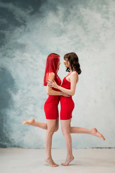 Fullständigt Porträtt Två Ömt Omfamnande Kvinnor Klädda Identiska Röda Klänningar — Stockfoto