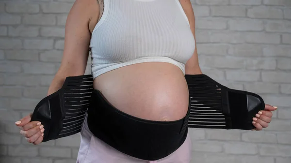 Μια Έγκυος Γυναίκα Βάζει Έναν Μαύρο Επίδεσμο Καλλιεργημένη Κοιλιά — Φωτογραφία Αρχείου