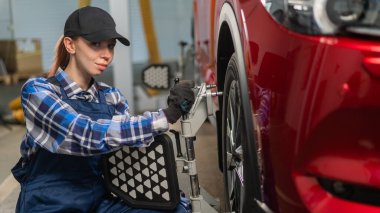 Kadın bir oto tamircisi bir camber yapar. Araba servisinde çalışan bir kadın.