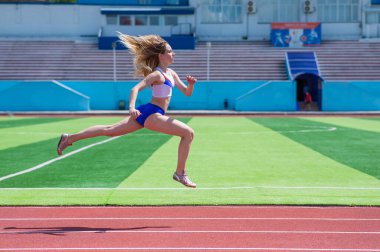 Genç beyaz kadın açık hava stadyumunda koşuya çıktı.