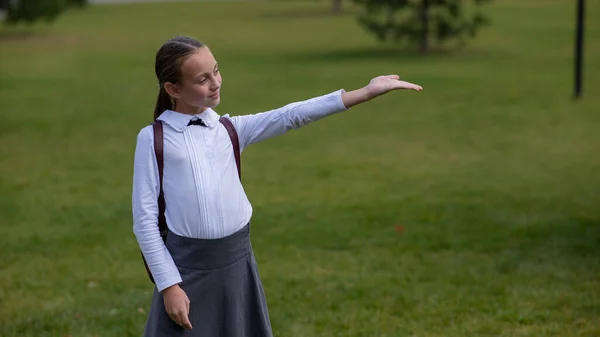 Kaukaska Dziewczyna Mundurze Plecakiem Wskazuje Puste Miejsce Świeżym Powietrzu Szkole — Zdjęcie stockowe