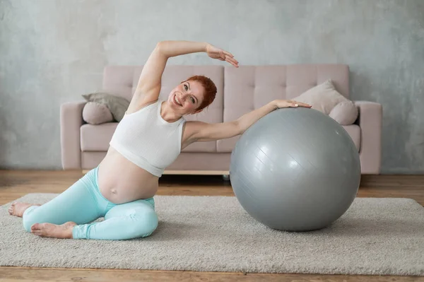 Zwangere Vrouw Doet Zijwaartse Bochten Met Een Fitness Bal Thuis — Stockfoto