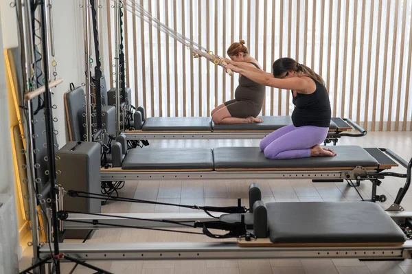 Dvě Těhotné Ženy Dělají Pilates Cvičení Reformátora — Stock fotografie
