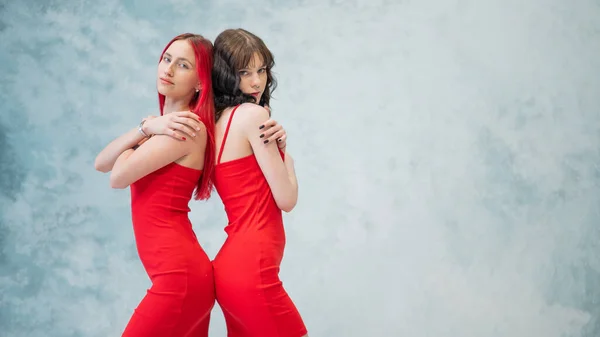 Portret Dwóch Kobiet Ubranych Identyczne Czerwone Sukienki Stojących Tyłem Siebie — Zdjęcie stockowe