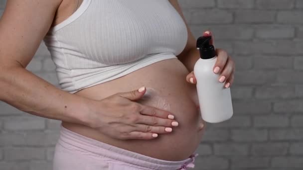 Крупный План Живота Беременной Женщины Применяющей Увлажняющий Крем Профилактика Растяжек — стоковое видео