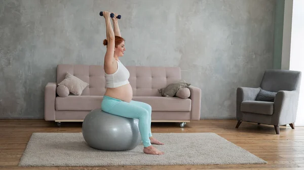 Těhotná Žena Dělá Cvičení Činky Při Sezení Fitness Míč Doma — Stock fotografie