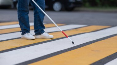 Yaya geçidinden sopayla geçen kör bir kadının bacaklarına yakın çekim.