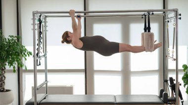 Reformcuda pilates yapan hamile bir kadın.