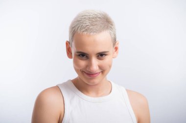 Beyaz bir arka planda kısa sarı saçlı güzel bir genç kadın.