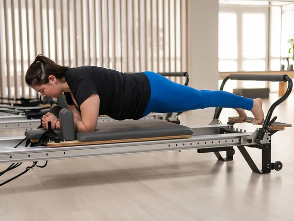 stock image Overweight caucasian woman doing pilates exercises on a reformer