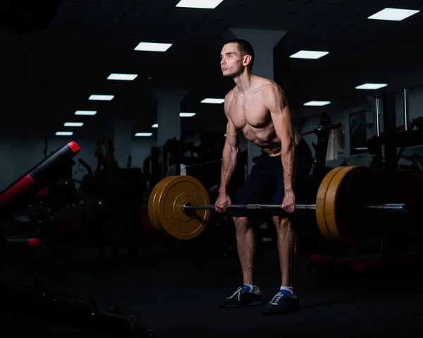 stock image Shirtless man doing bicep exercises with dumbbells in the gym