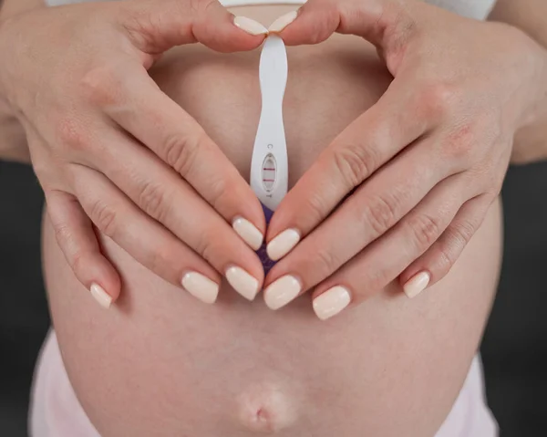 Beyaz Kadın Karnının Arka Planında Pozitif Bir Hamilelik Testi Tutuyor — Stok fotoğraf