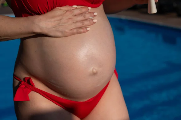 Zbliżenie Brzucha Ciężarnej Kobiety Opalającej Się Czerwonym Bikini Oczekująca Matka — Zdjęcie stockowe