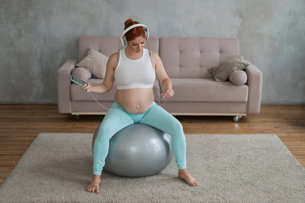 Kaukasische Roodharige Zwangere Vrouw Zit Fitball Luisteren Naar Muziek Met — Stockfoto