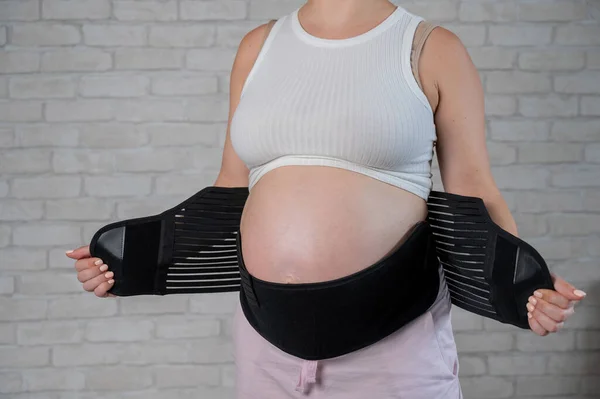 Una Mujer Embarazada Pone Vendaje Negro Dos Piezas Vientre Recortado —  Fotos de Stock