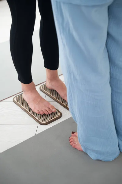 stock image Caucasian woman stands on sadhu boards with therapist support