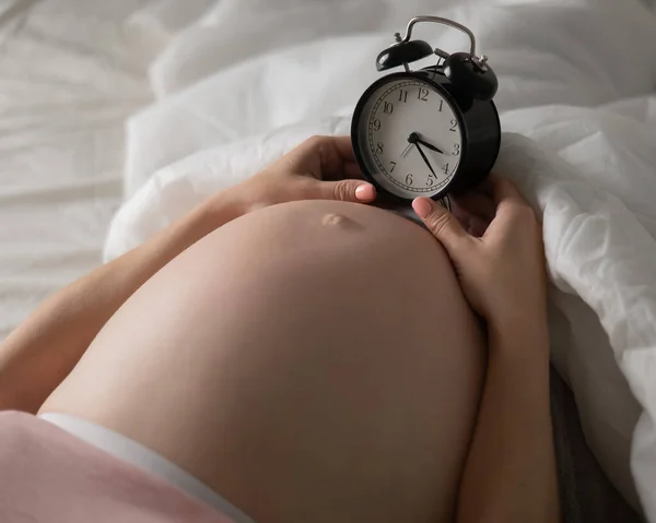 Těhotná Žena Leží Posteli Budík Zblízka Břiše — Stock fotografie