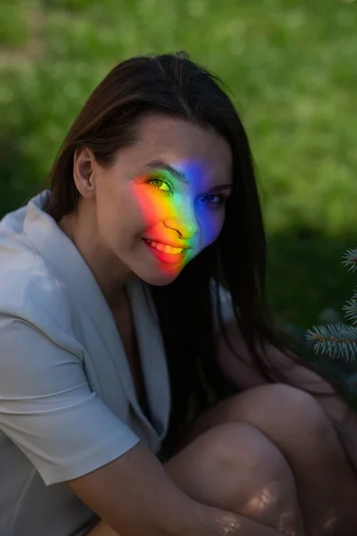 虹のビームを持つ白人女性の肖像画彼女の顔に屋外 — ストック写真