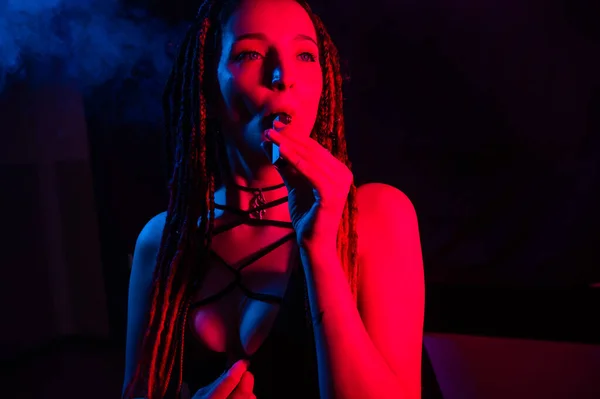 Caucasian Girl Dreadlocks Smokes Vape Red Blue Light — Stock Photo, Image