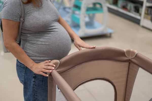 Blanke Zwangere Vrouw Kiest Een Box Wieg Een Kinderwinkel — Stockfoto