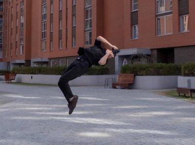 Adam dışarıda takla atarken fotoğraf çekiyor.