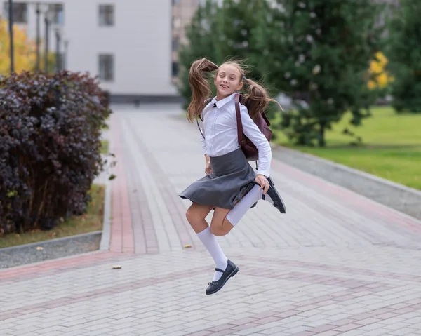 Menina Caucasiana Feliz Uniforme Com Uma Mochila Pulando Livre Depois — Fotografia de Stock