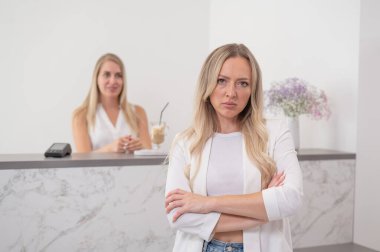 Memnun olmayan müşteri güzellik salonunun resepsiyonunda duruyor.