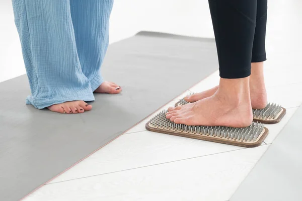 stock image Caucasian woman stands on sadhu boards with therapist support