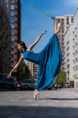 Dışarıda dans eden güzel bir Asyalı balerin. Şehir manzarası
