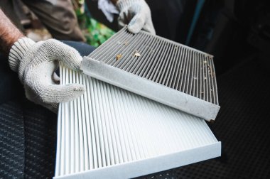 Usta arabanın kabin hava filtresini değiştiriyor.