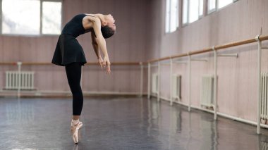 Asian woman dancing in ballet class. Bending in the back
