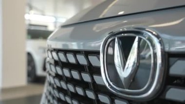 Bir araba galerisindeki Changan arabasının tamponuna yakın çekim. Hareket eden kamera