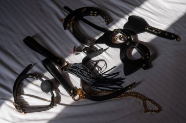 Siyah deri bdsm beyaz çarşafta ayarlandı