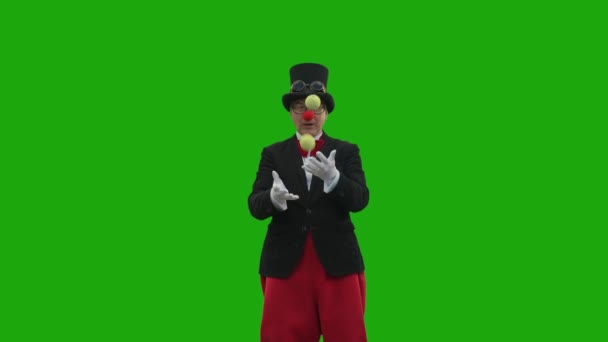 Een Oudere Man Een Clownspak Jonglert Met Ballen Een Groene — Stockvideo