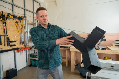 Marangoz ahşap parçalar için bir metal konnektör tutuyor.