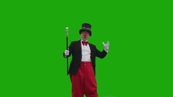 Äldre Man Clowndräkt Går Mot Grön Bakgrund Med Käpp Händerna — Stockvideo