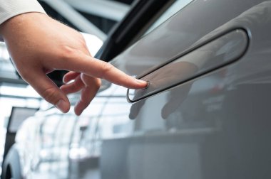 Adamın biri parmak iziyle arabanın kapısını açıyor. Bütünleşik kulp